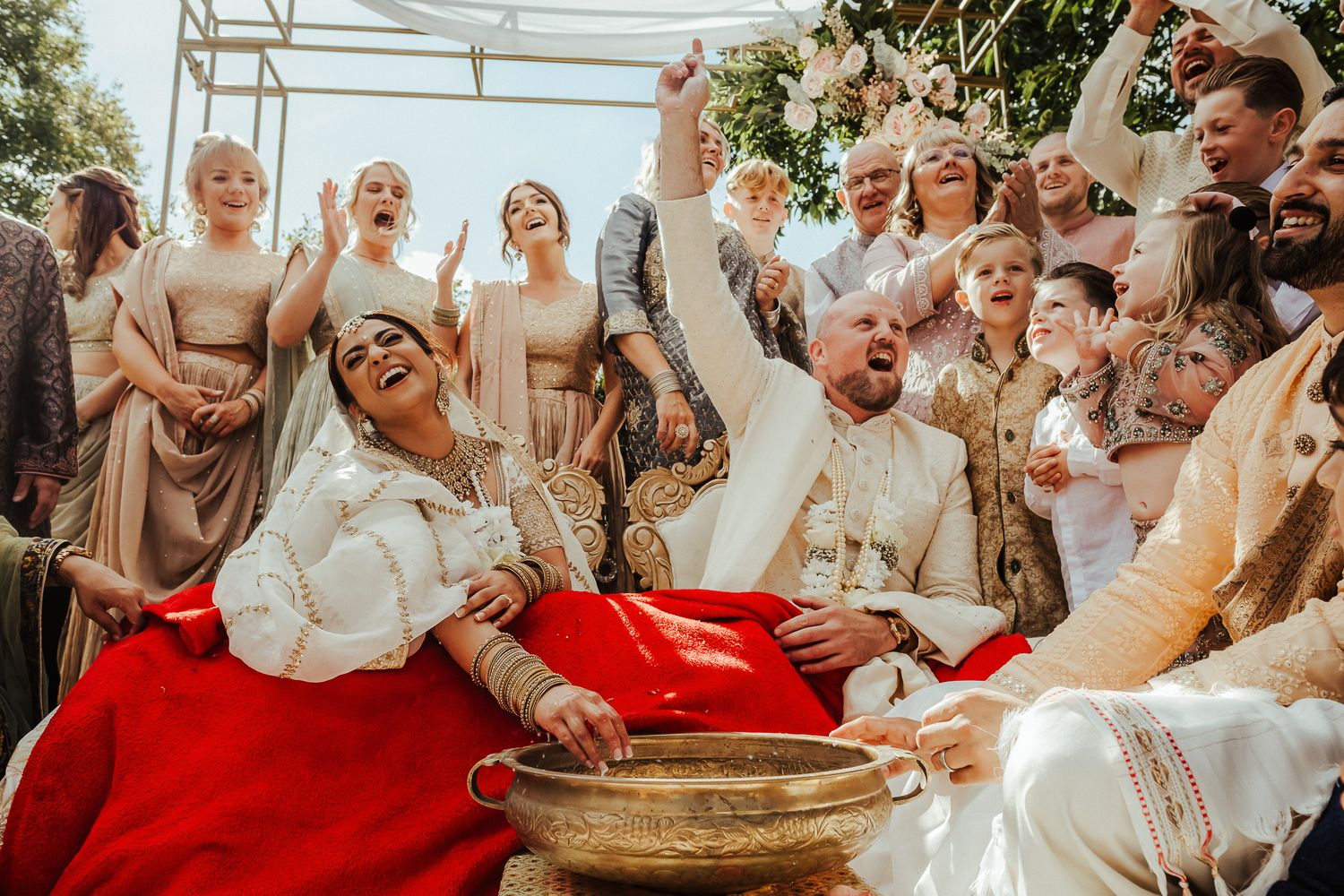 Wedding guests gathered on stairs for group photo displaying joyful reactions and celebration.