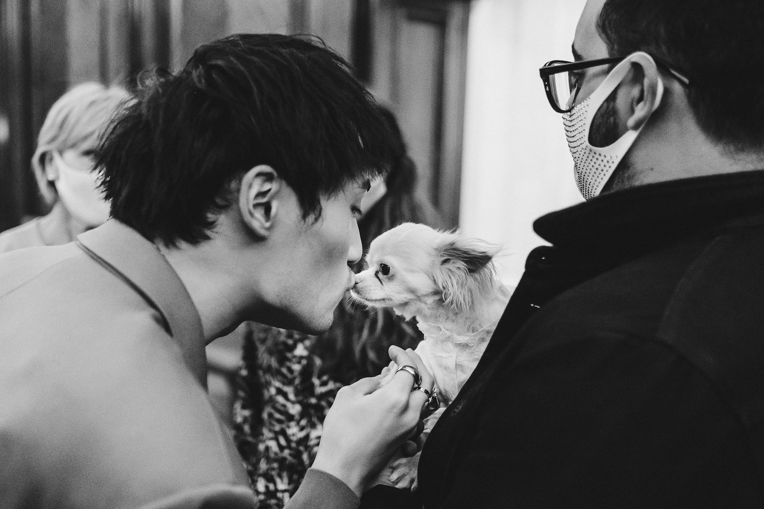 Candid black and white moments between wedding guests during reception celebration.
