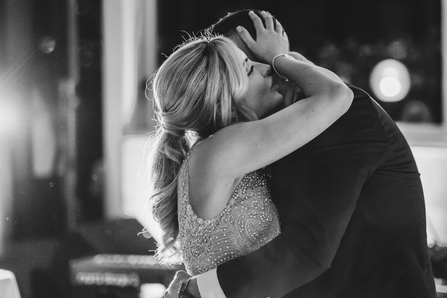 Black and white intimate dance moment at an indoor wedding reception.