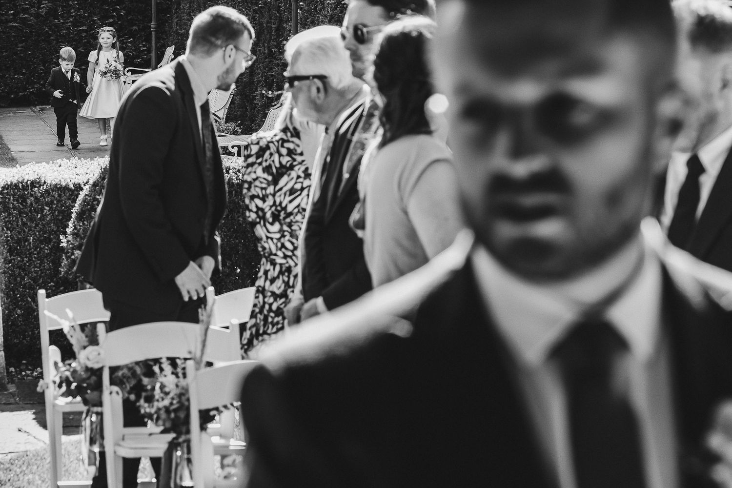 Black and white photo of people gathering at an outdoor event.