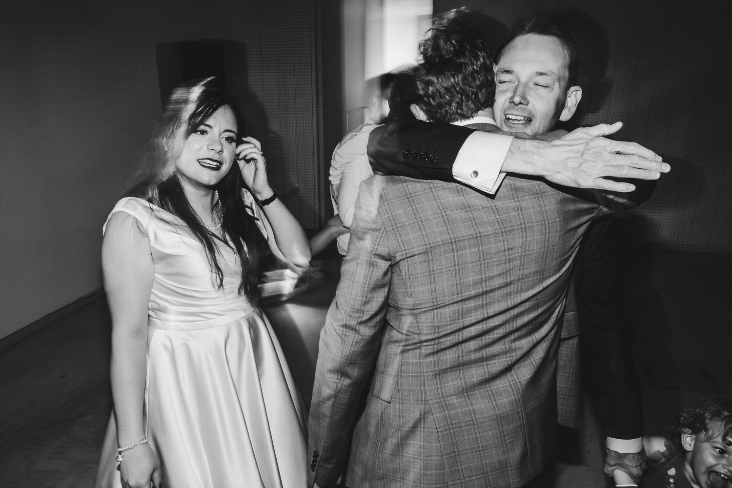 Black and white candid shot of wedding couple sharing a joyful moment.