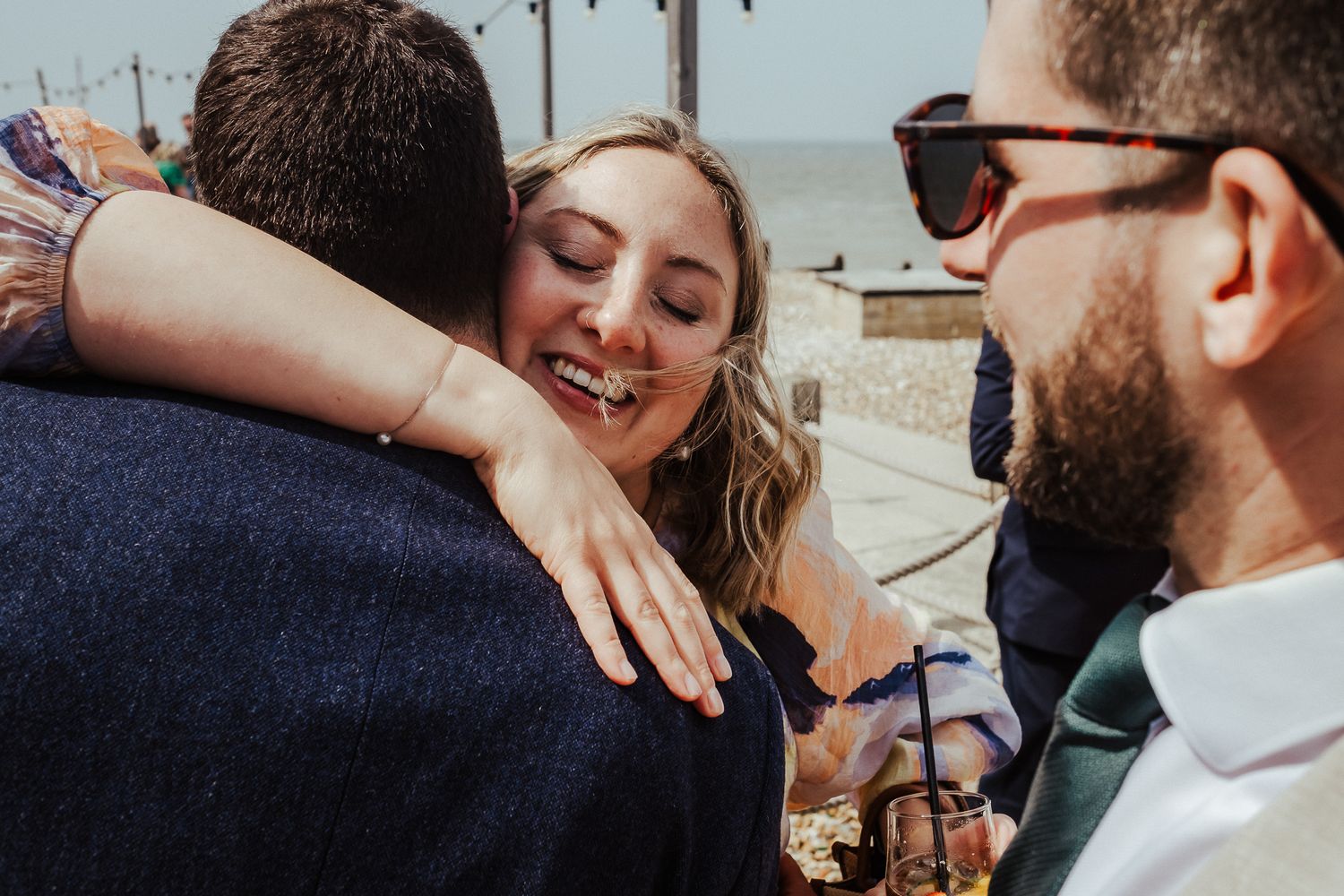 Bridesmaids in olive dresses take shots together during wedding festivities.