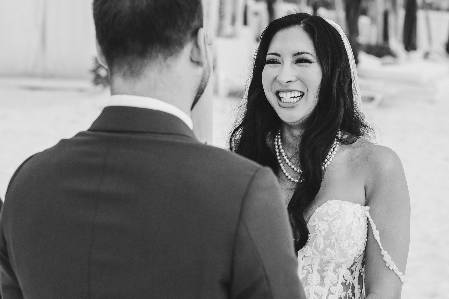 Black and white candid moment during beach wedding ceremony.