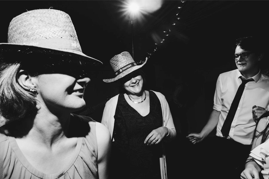 Black and white candid shots of wedding guests dancing and celebrating.