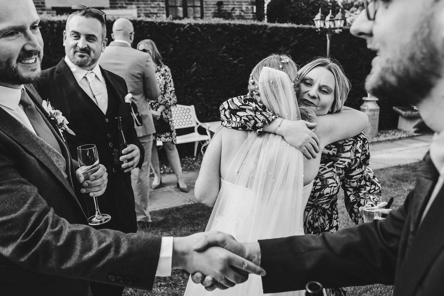 Black and white candid shots of wedding guests mingling during reception festivities.