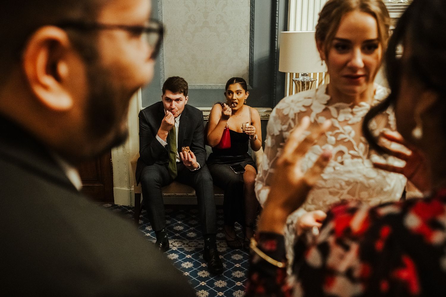 Candid reception moment with guests mingling in hallway during wedding celebration.