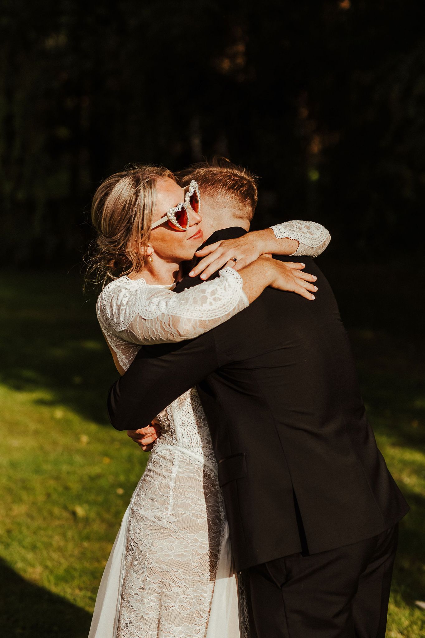 Intimate moment between newlyweds embracing in golden sunlight.