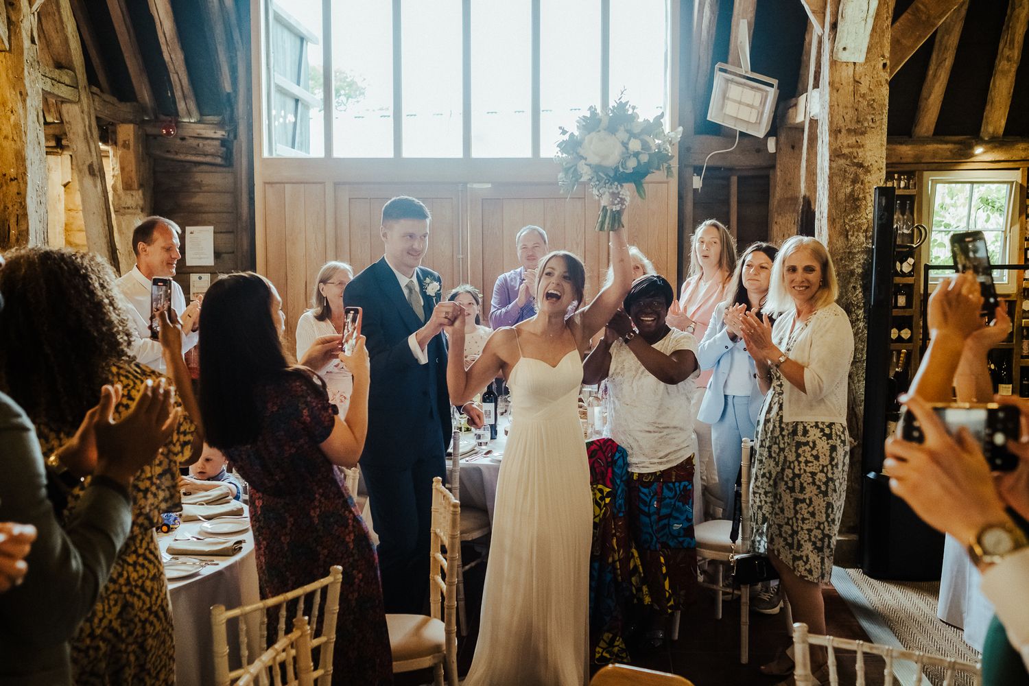 Wedding reception guests dancing and celebrating in an indoor venue.