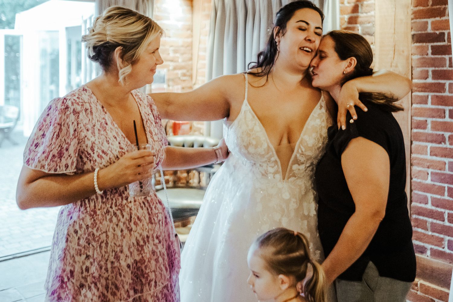 Wedding guests share joyful moments and drinks during an indoor celebration.