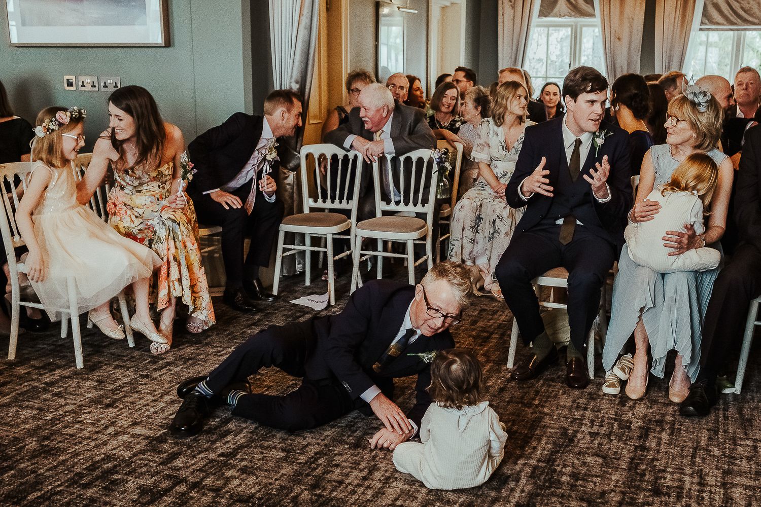 A playful moment unfolds during a wedding reception as guests interact on the dance floor.