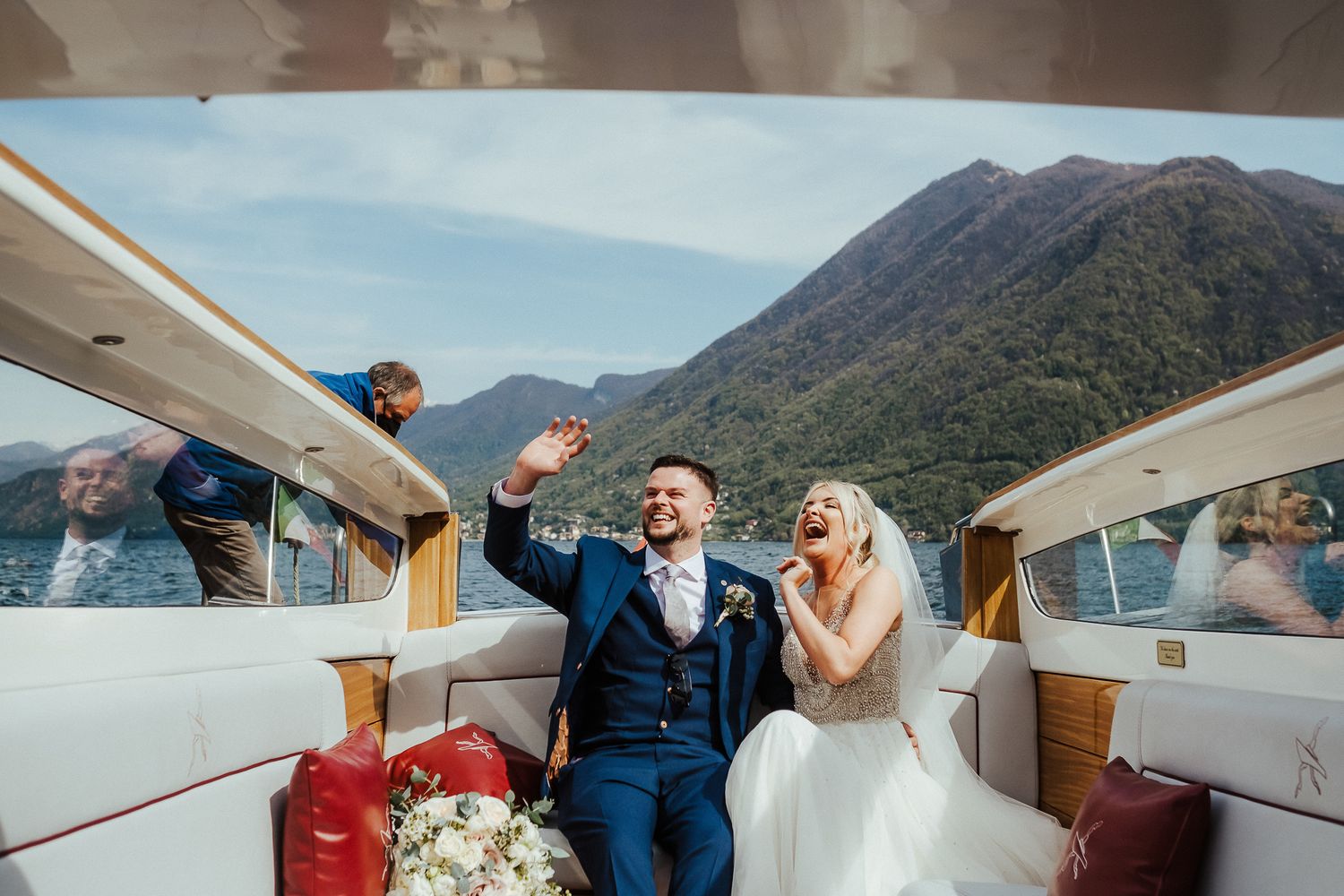 Newlyweds celebrate with champagne on a luxury boat ride on Lake Como.