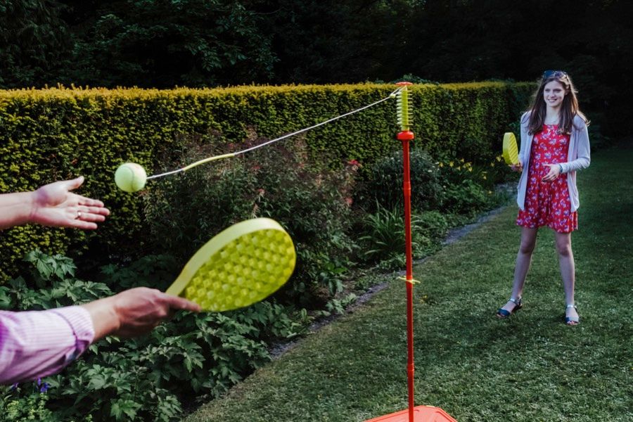 Wedding guests play lawn games at an outdoor reception.
