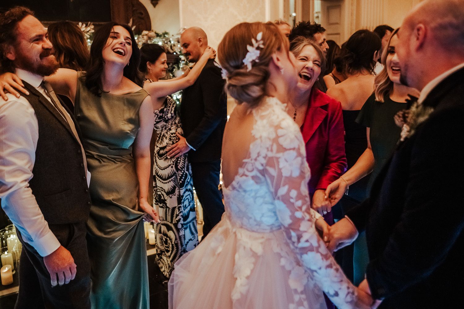 Guests enjoying themselves at a wedding reception with expressive dancing and laughter.