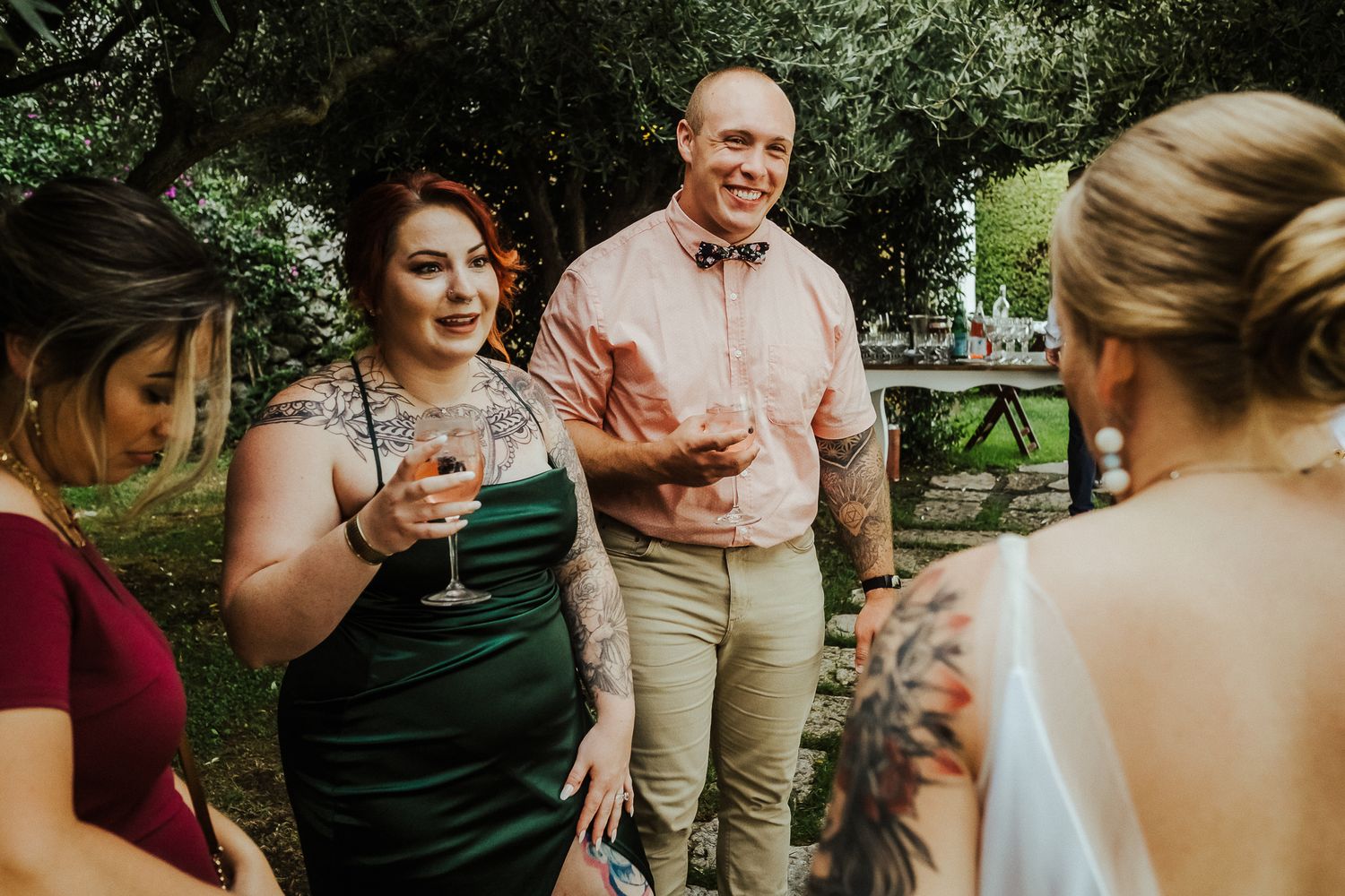 Wedding guests enjoying drinks and conversation during an outdoor garden reception.