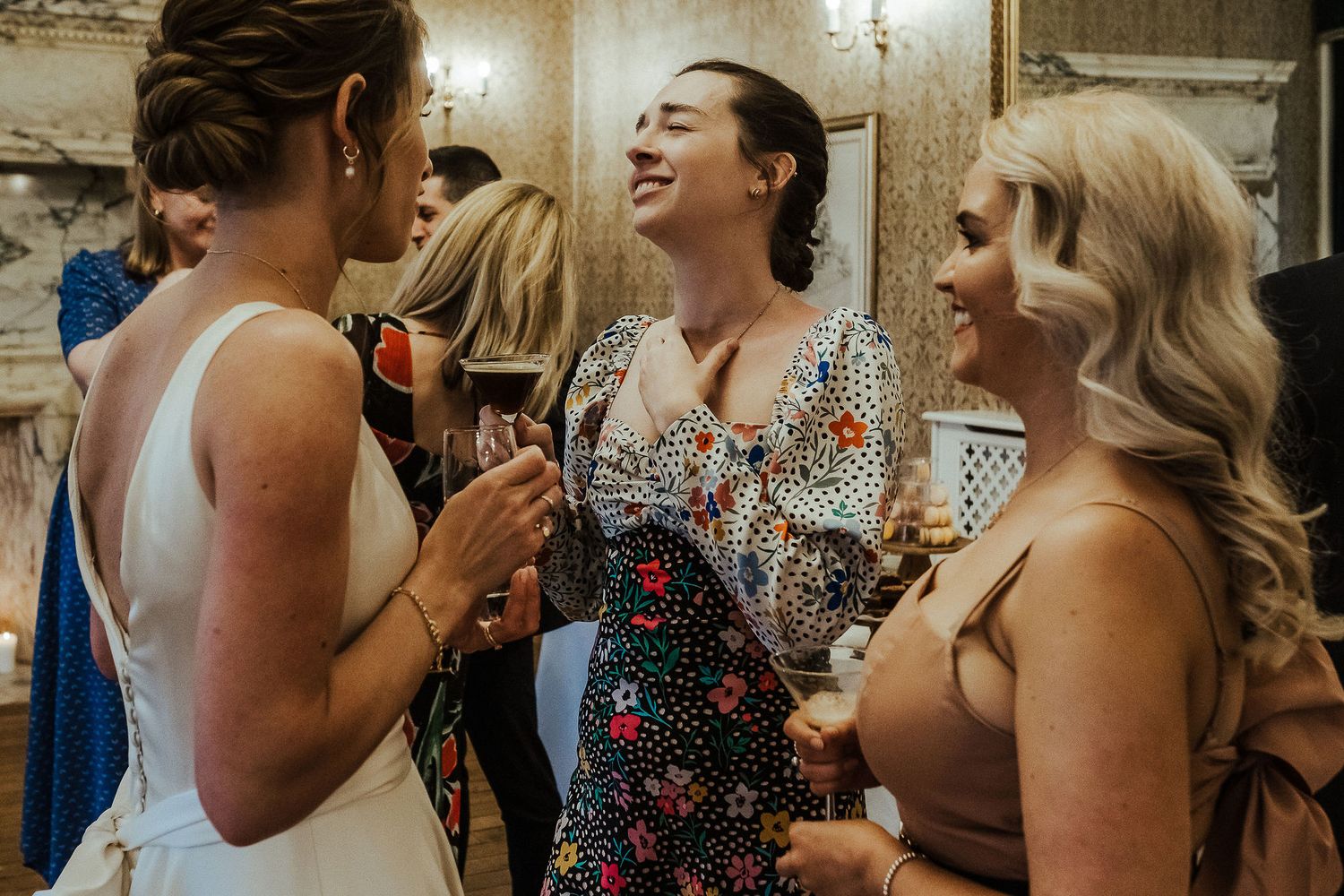 Wedding guests mingle and socialize during an elegant indoor cocktail reception.