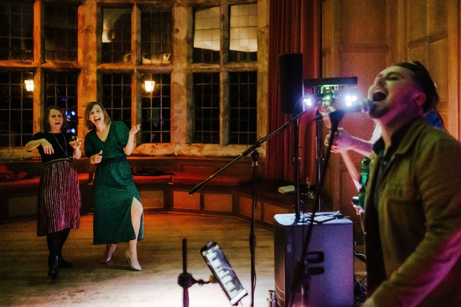 Live band performs at a vintage venue with dramatic lighting and wooden interior decor.