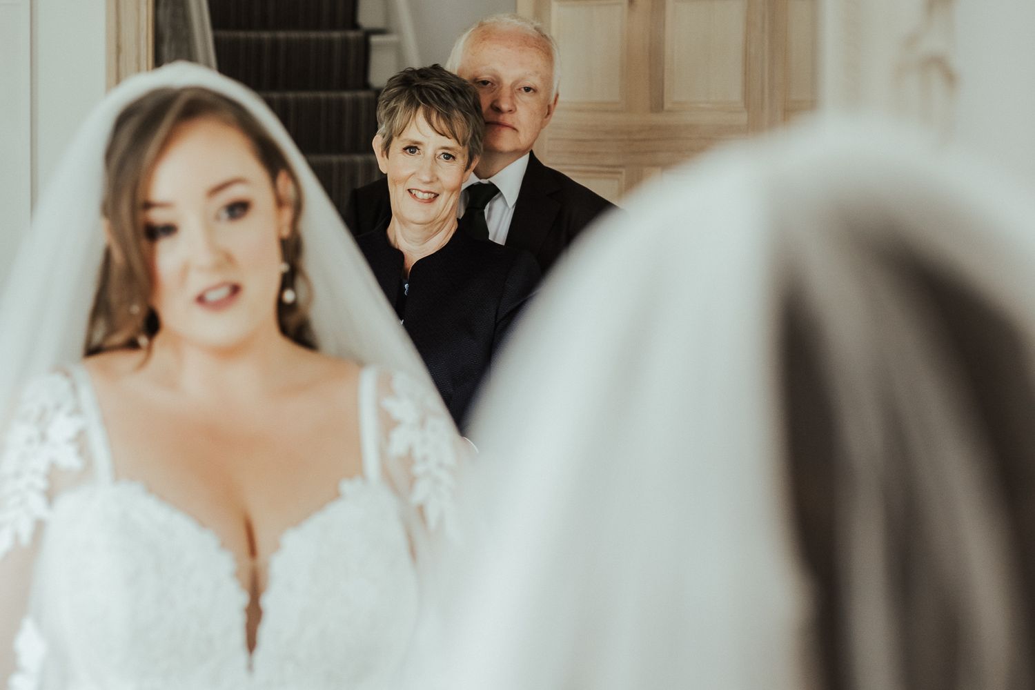 Wedding moment showing bridal party members peeking around a corner during the ceremony preparations.