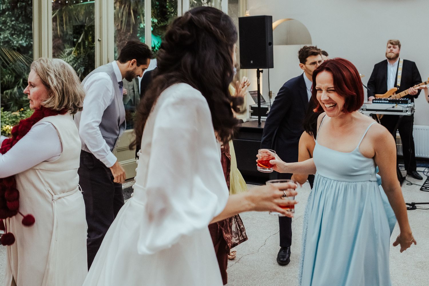 Wedding guests in light blue dresses mingling at an outdoor celebration.