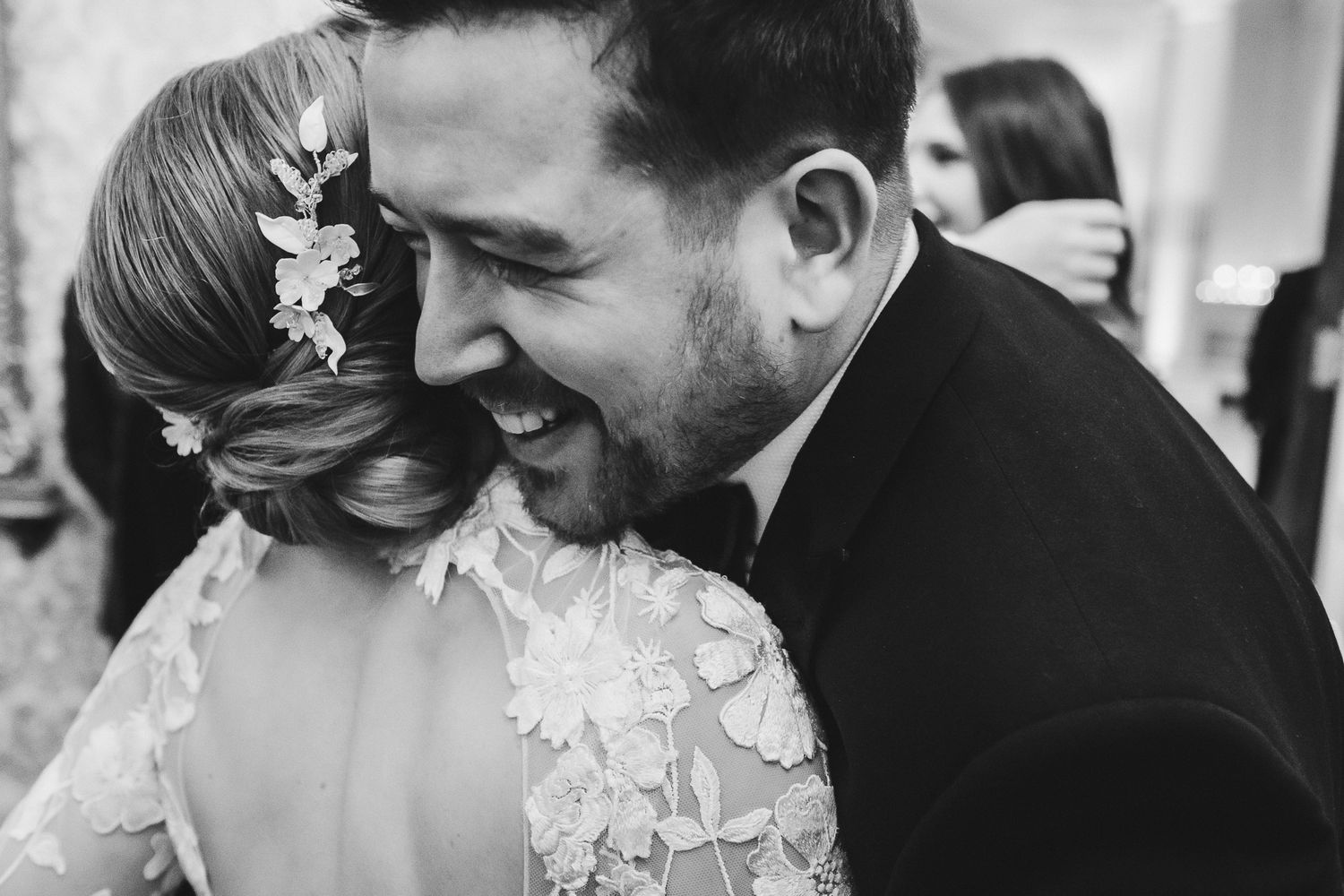 Close-up black and white shot of intimate moment between couple during wedding celebration.