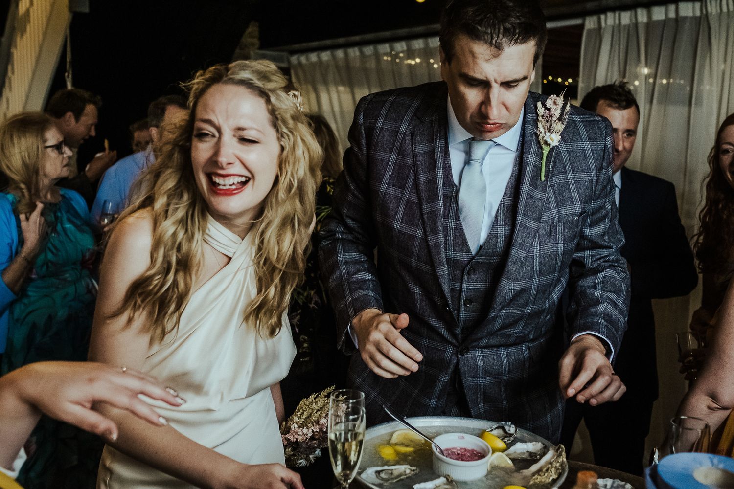 Wedding reception guests enjoying dinner and conversation at decorated tables.