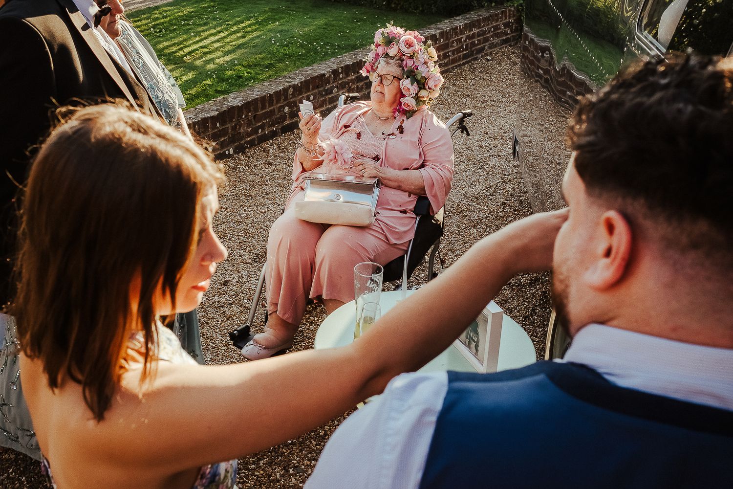 Intimate outdoor wedding moment as couple interacts with guests at sunset.