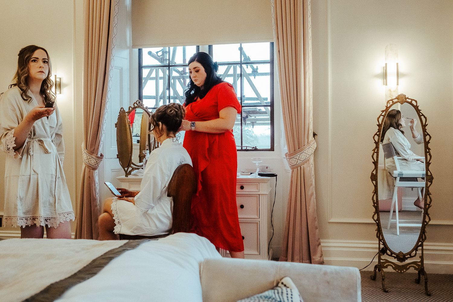 Elegant bridal preparation moments in a sunlit room with vintage furniture.