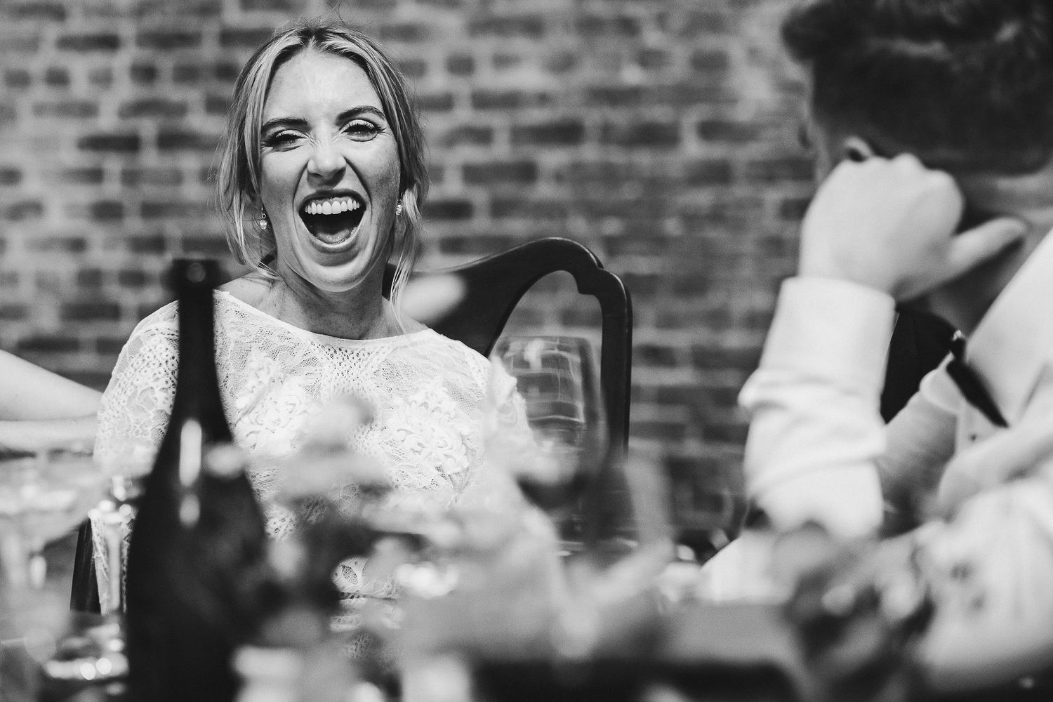 Natural reactions and laughter during wedding reception toasts.