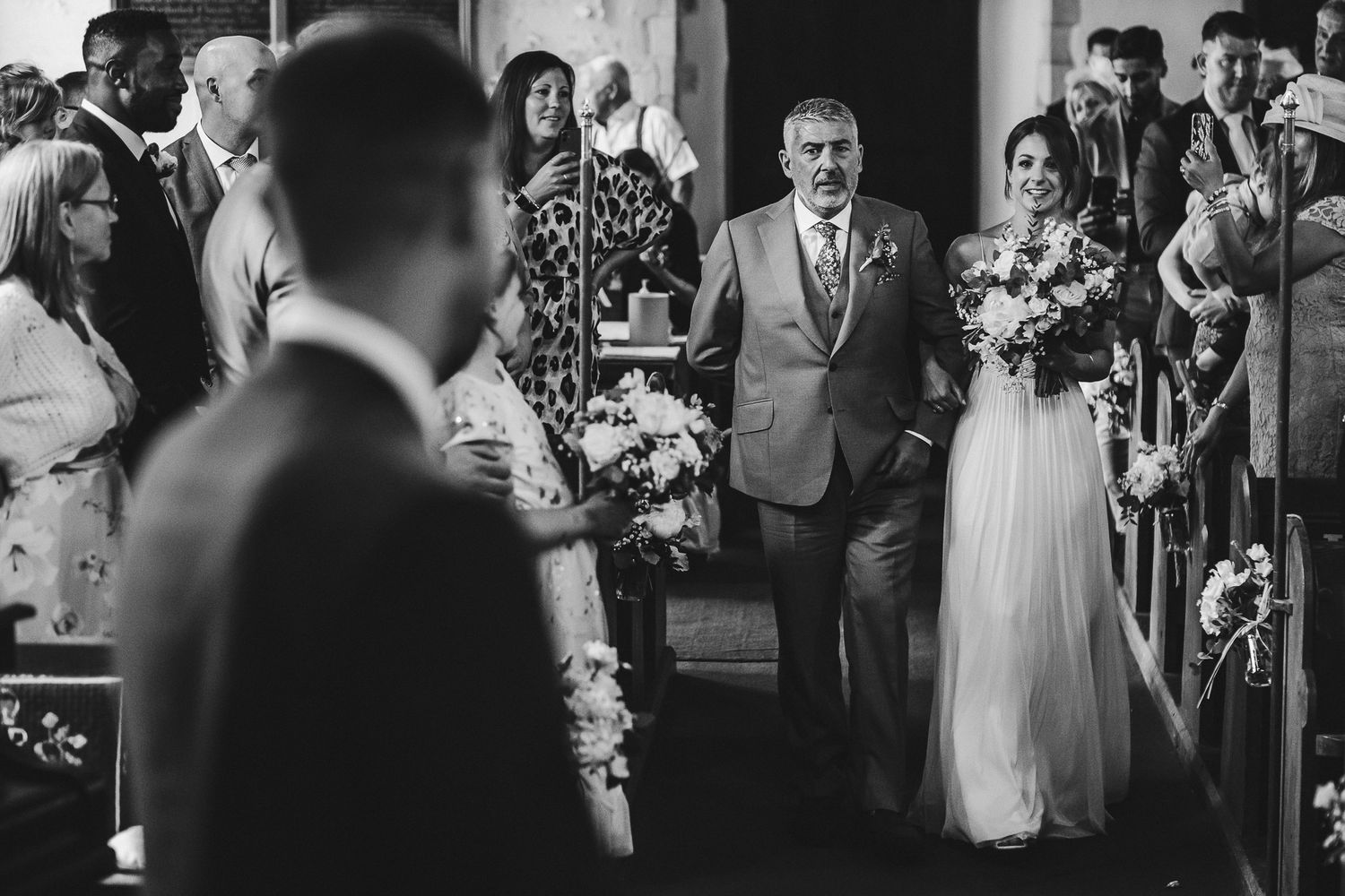 Black and white wedding party hugging and embracing in a joyful celebration moment.