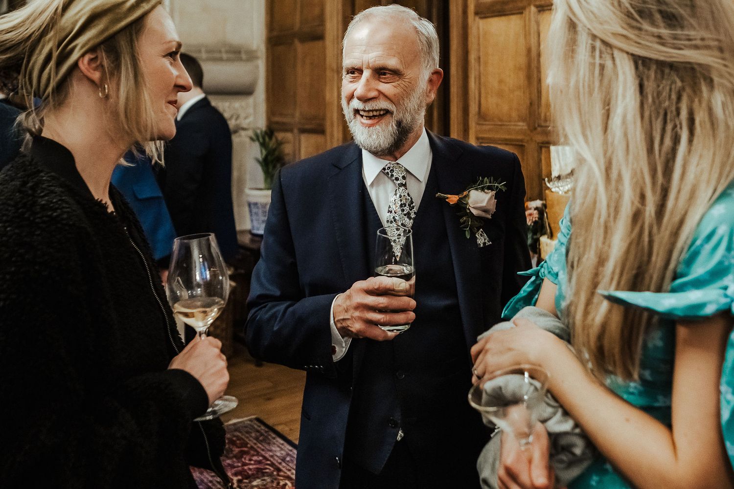 Elegant wedding reception with guests mingling and enjoying drinks in formal attire.