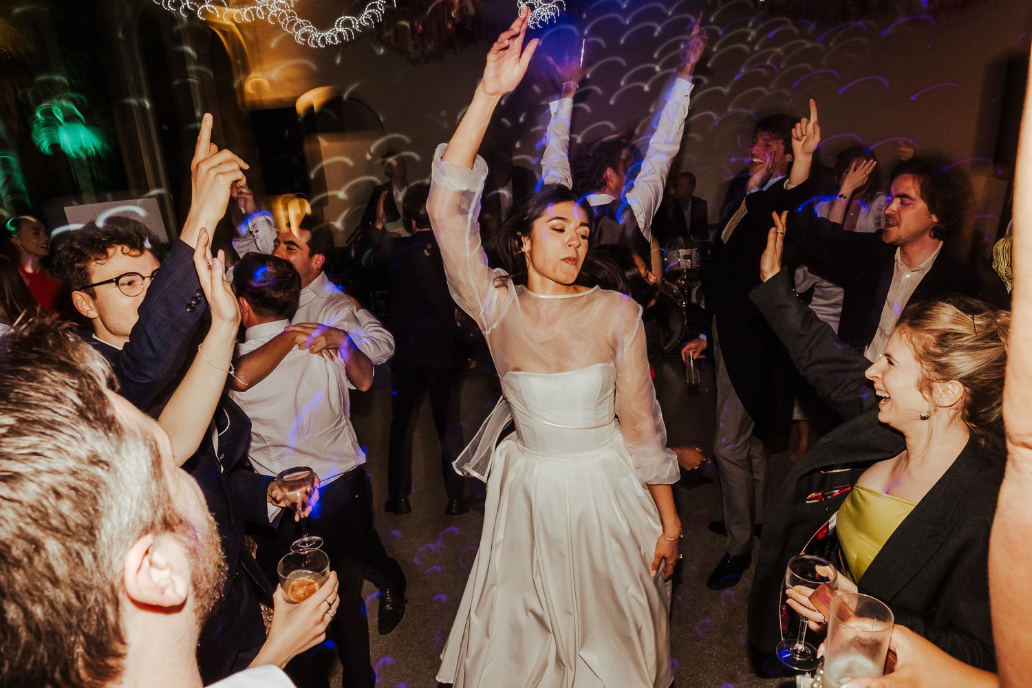 Wedding reception dance party with guests celebrating on a crowded dance floor.