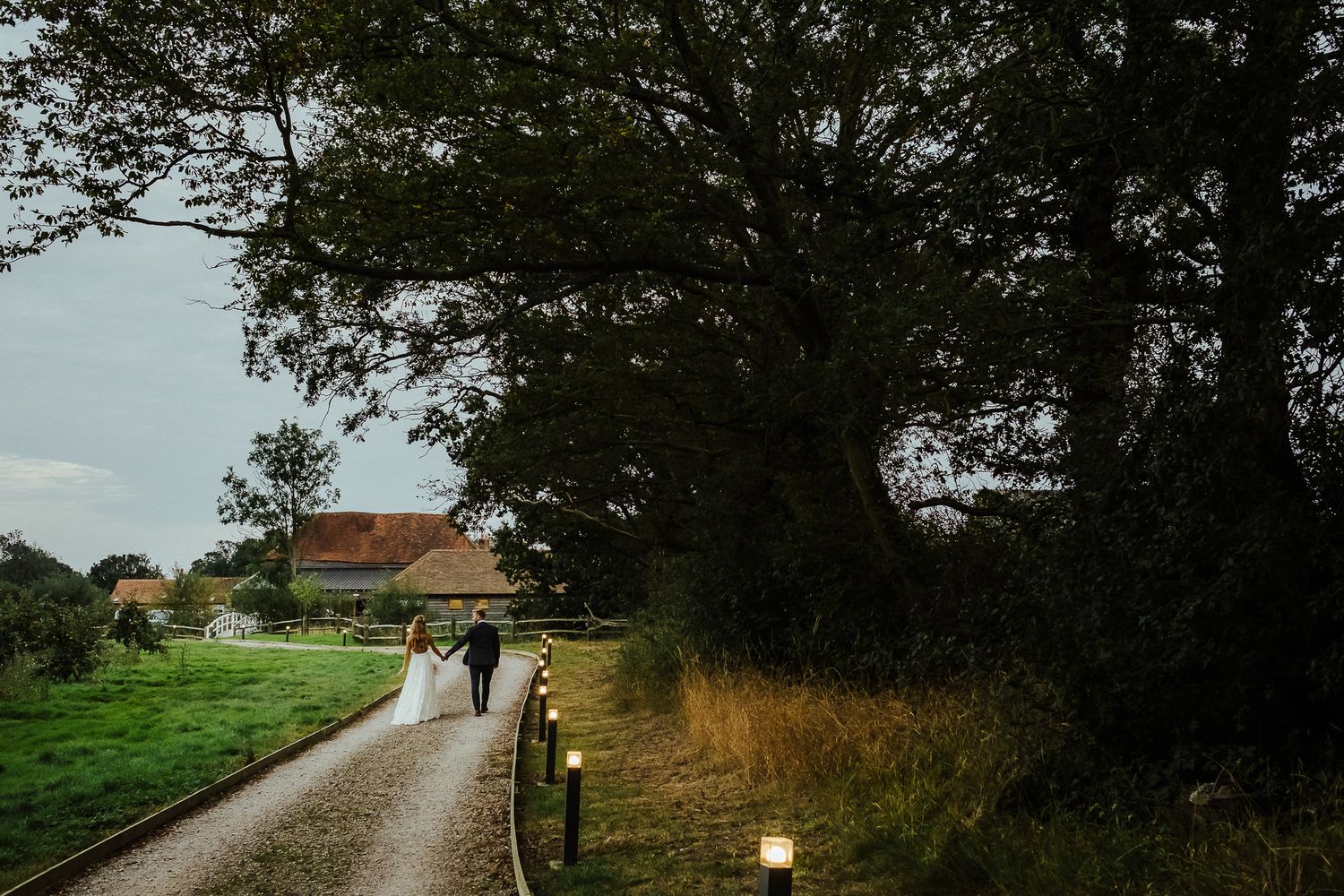 A scenic countryside wedding venue with a winding path through green fields.