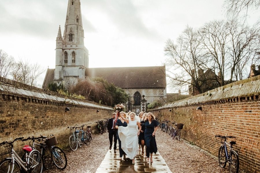 Panoramic view of a historic church path with bicycles parked along brick walls.