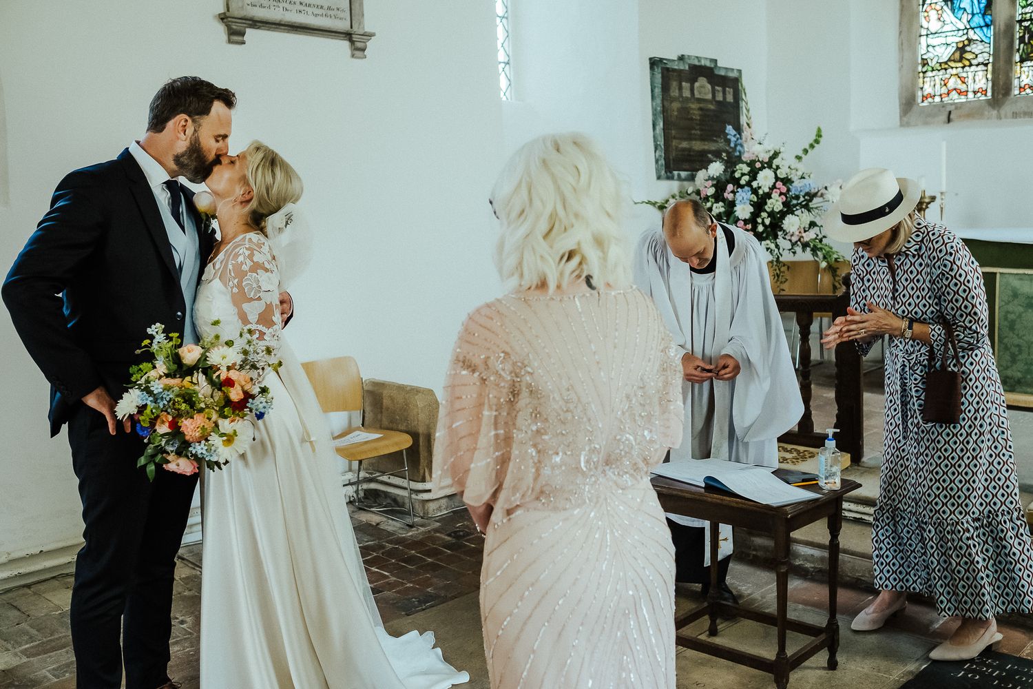 Elegant church interior with stained glass windows during a wedding ceremony.