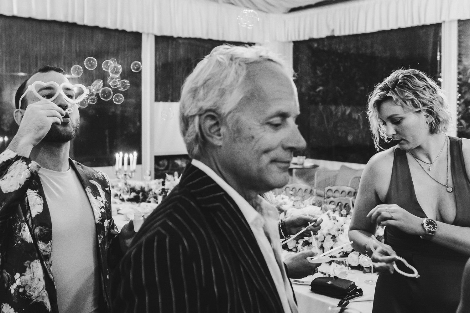Wedding reception guests enjoying lively conversations at an elegant outdoor gathering.