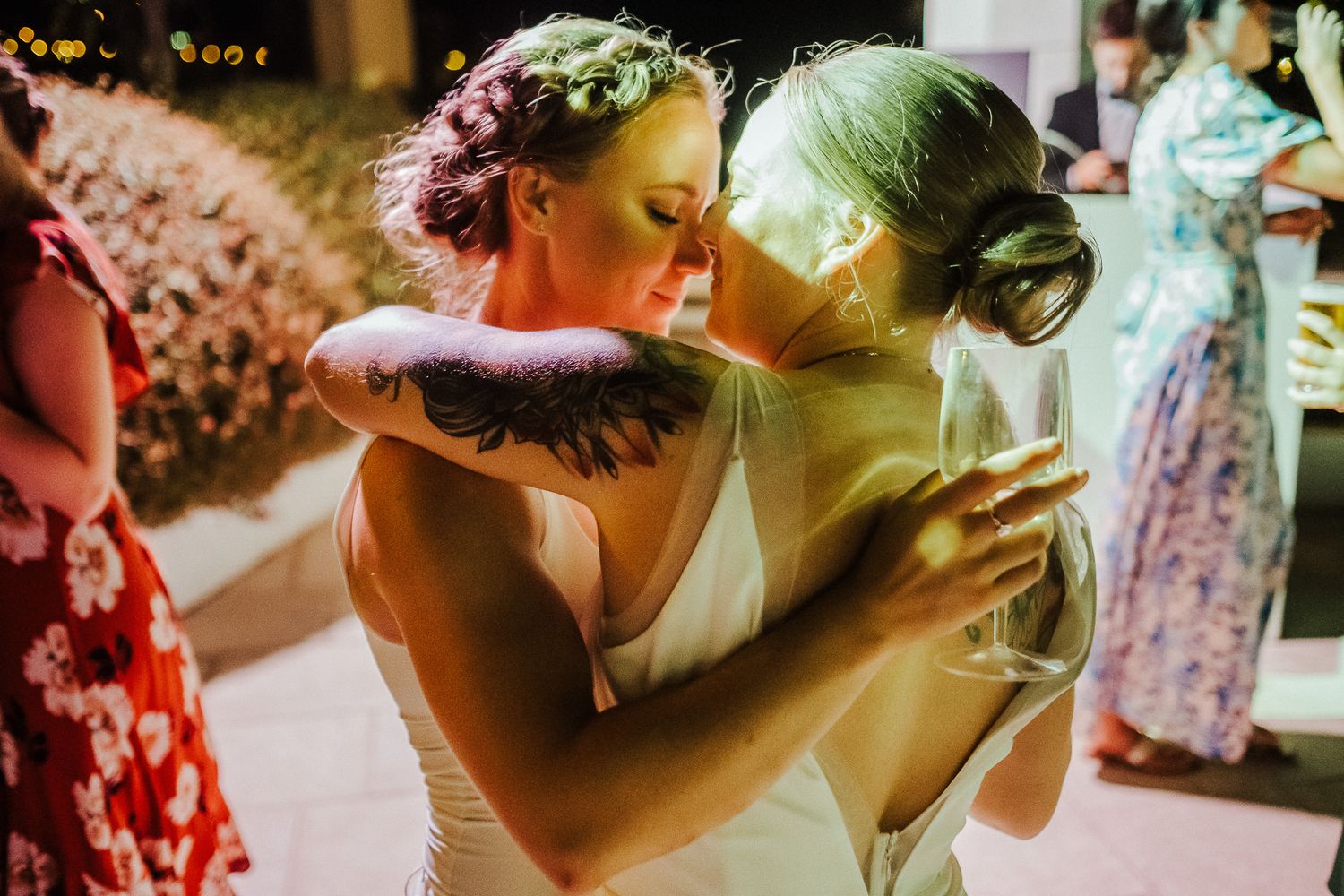Two people share an emotional embrace during a wedding reception.