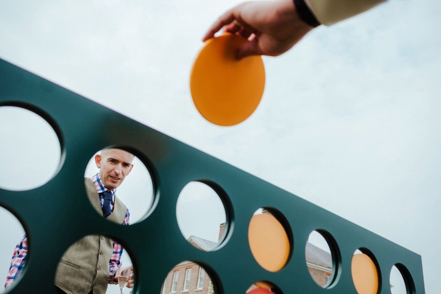 Creative photo composition through circular holes in a blue wall.