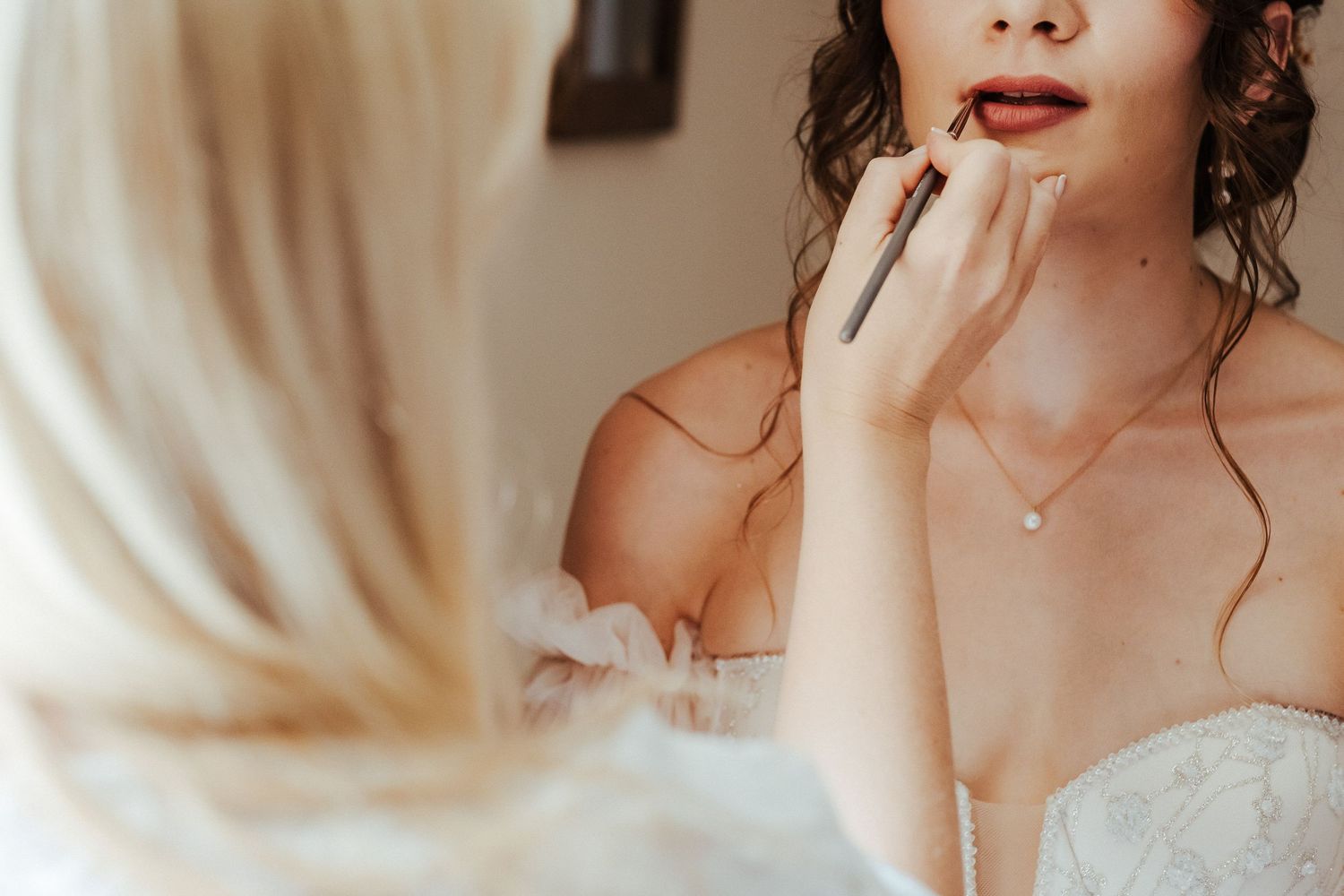 Close-up of bridal makeup application with soft natural lighting.