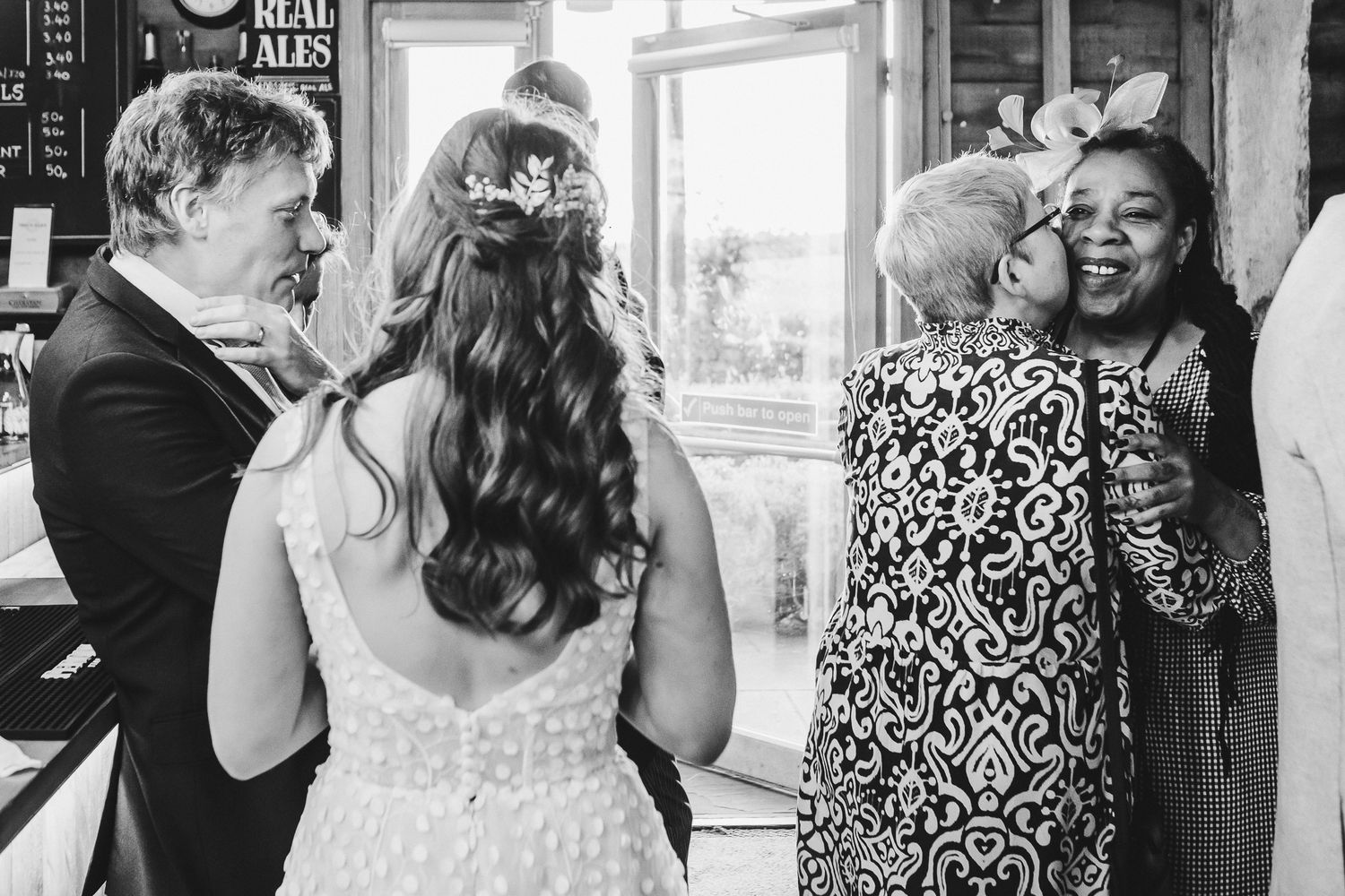 Wedding guests socializing and celebrating at an indoor reception venue.
