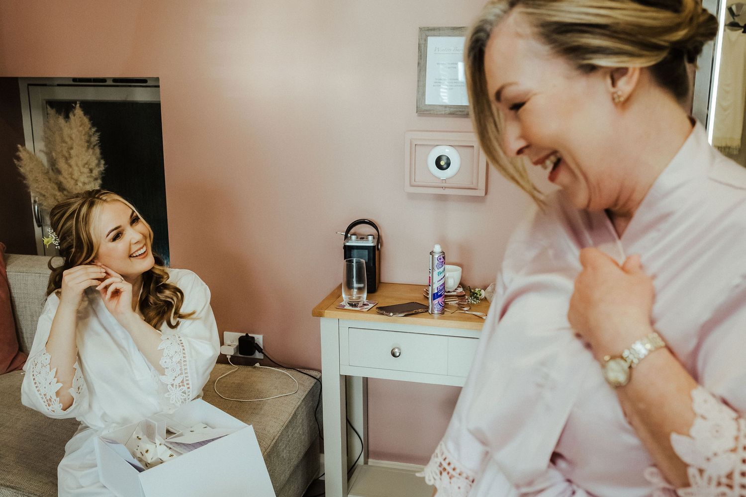 Joyful laughter shared between people getting ready in bridal suite.