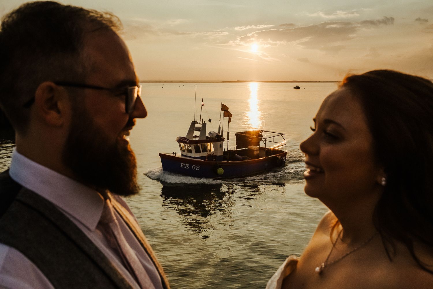 A romantic sunset moment with a boat silhouetted in the background water.