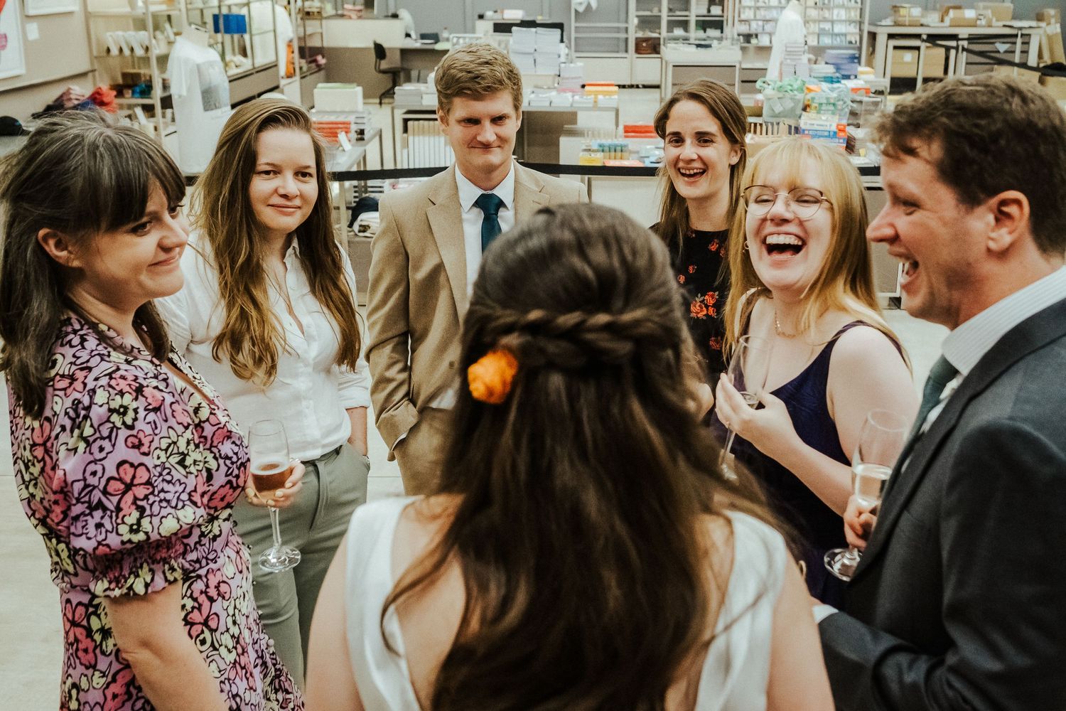 Wedding guests share stories and laughter during an indoor reception.