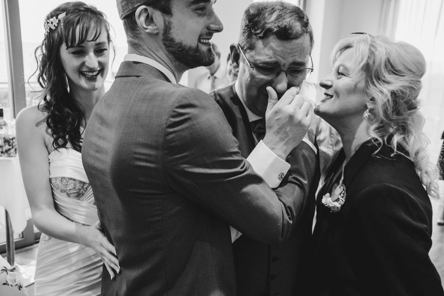 Black and white candid moments of celebration and laughter at a wedding reception.