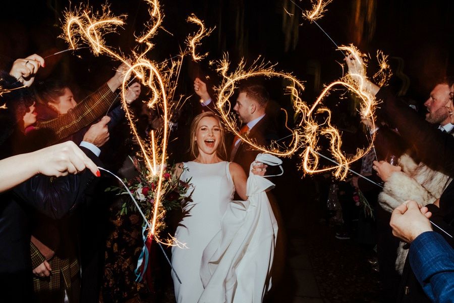 Wedding guests celebrating with sparklers during an evening reception celebration.