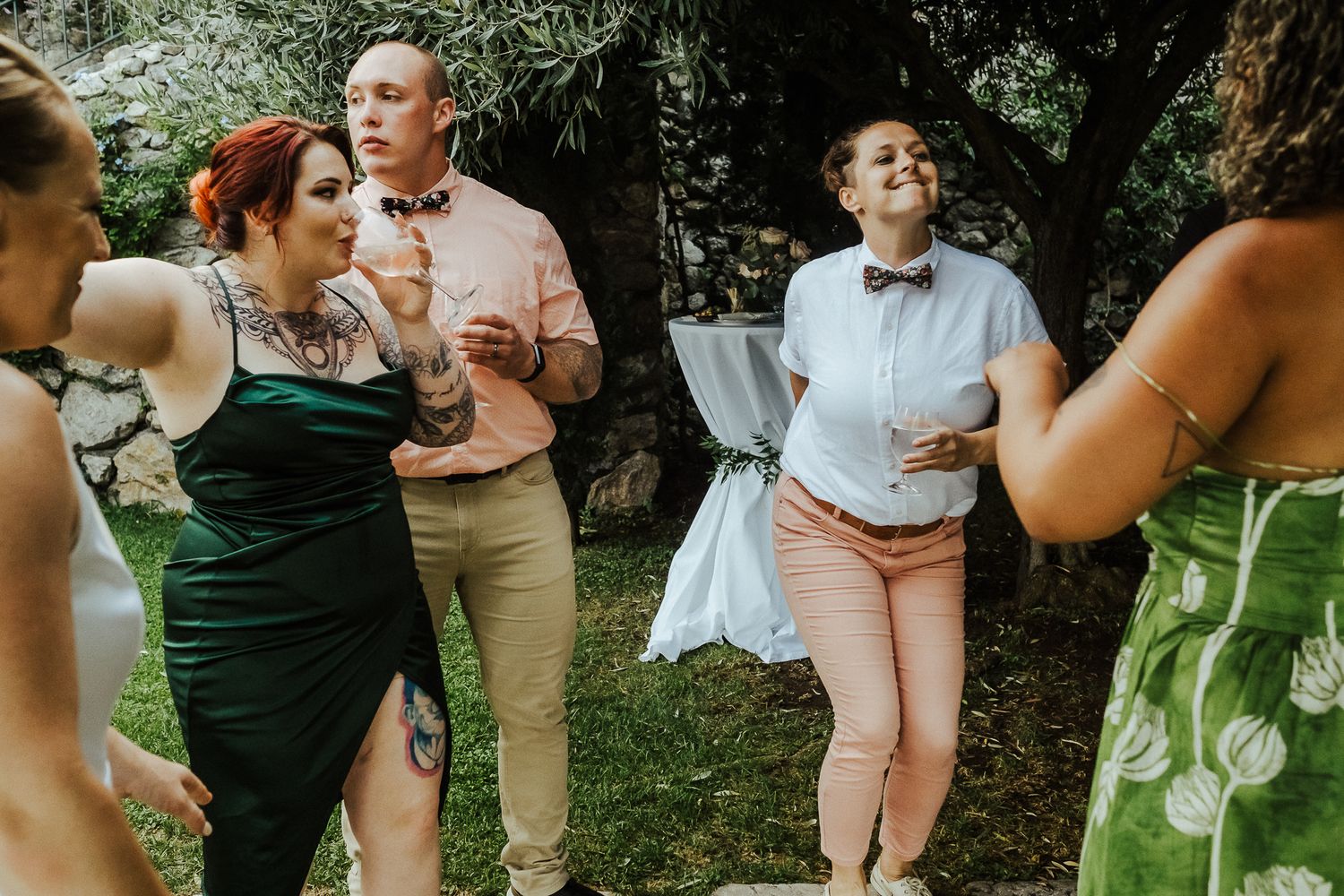 Wedding guests socializing and enjoying drinks during an outdoor garden party.