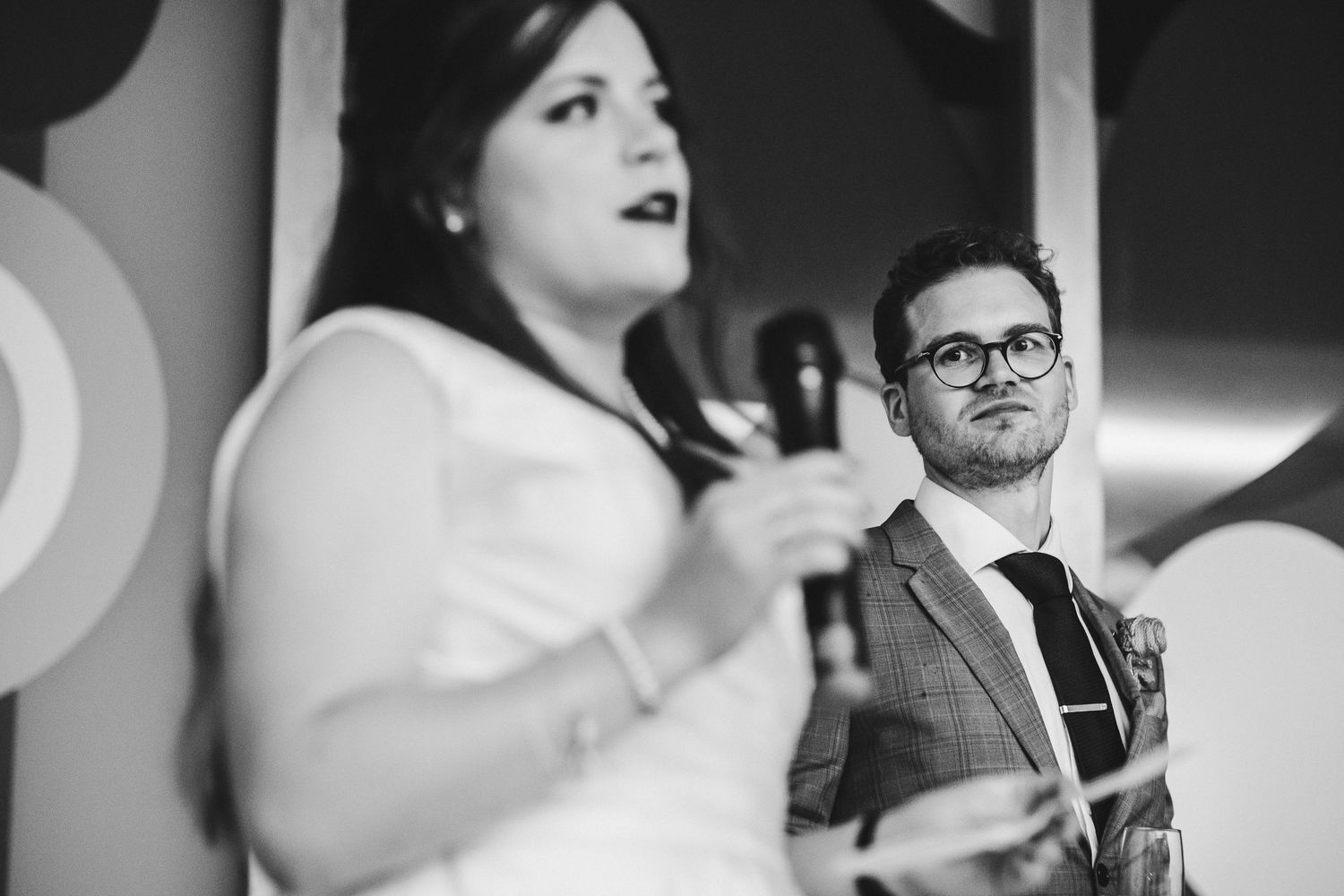 Black and white candid shots of guests enjoying emotional moments at a wedding reception.