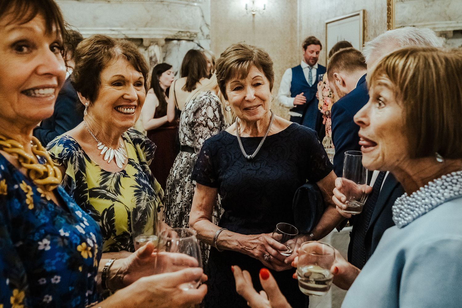 Group of women socializing and enjoying drinks at an elegant event.
