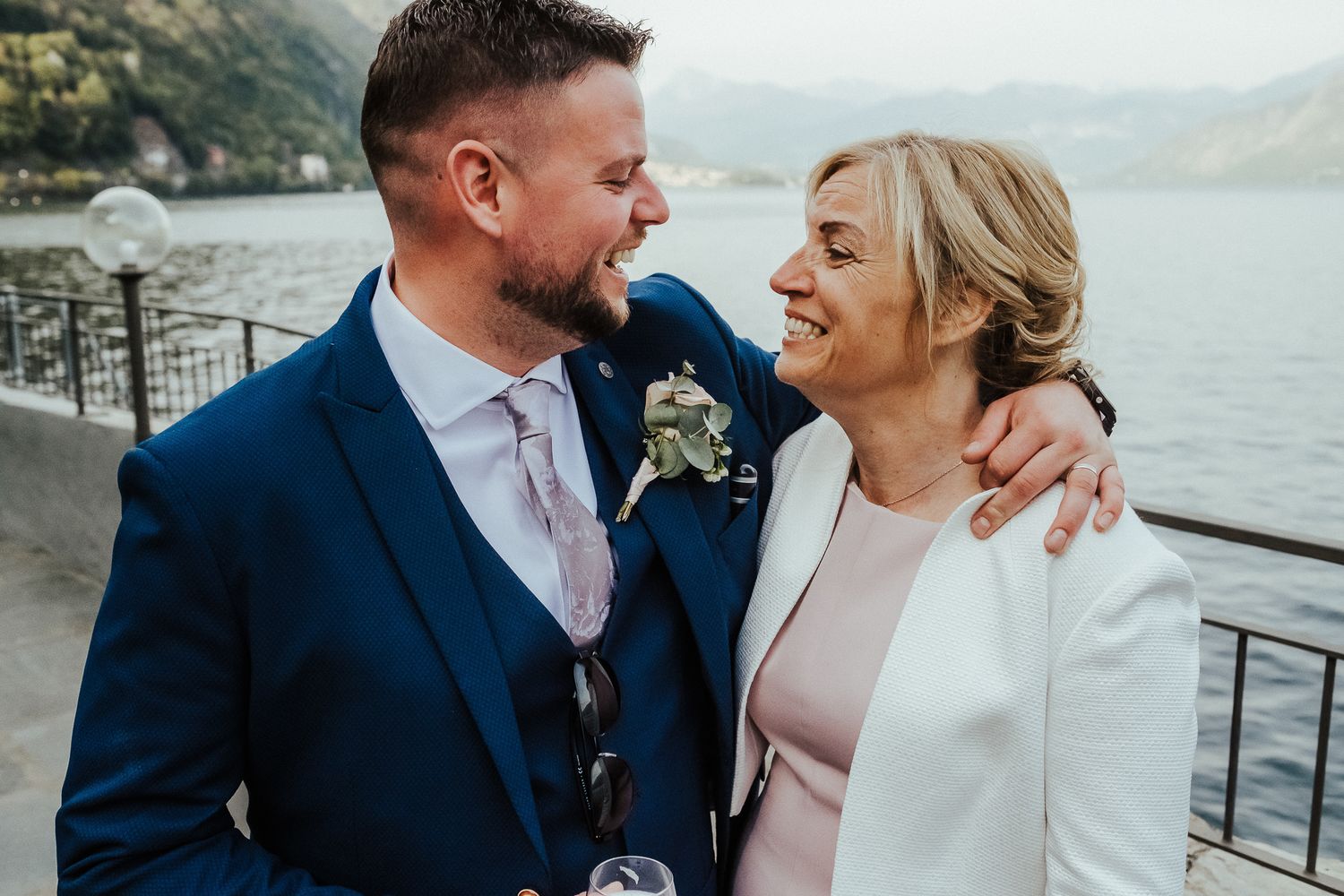 Romantic waterfront portrait of a couple in wedding attire.