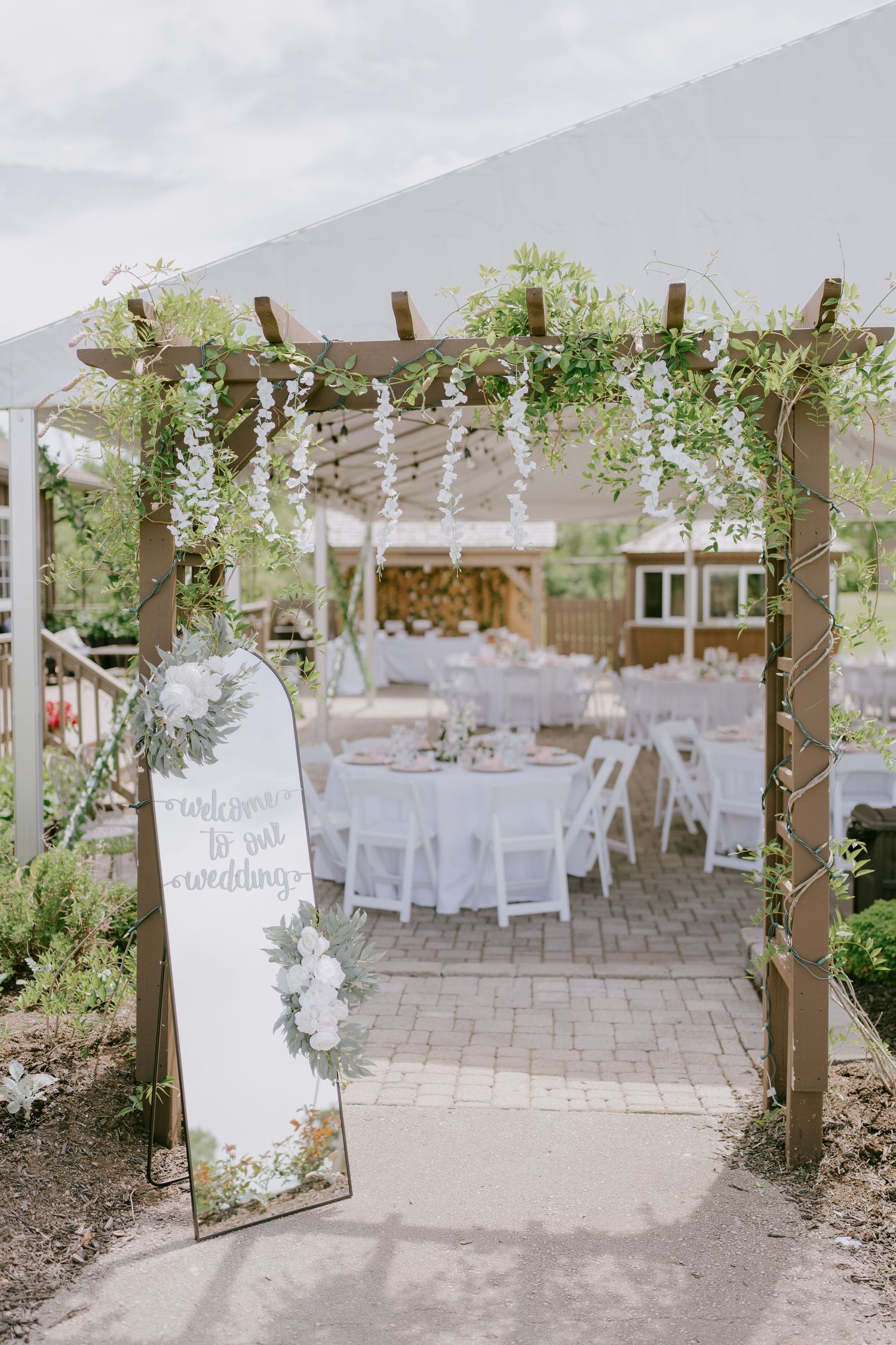 Outdoor wedding reception tent with round tables and welcome sign in Buncrana Golf, Ontario, Toronto and Durham region