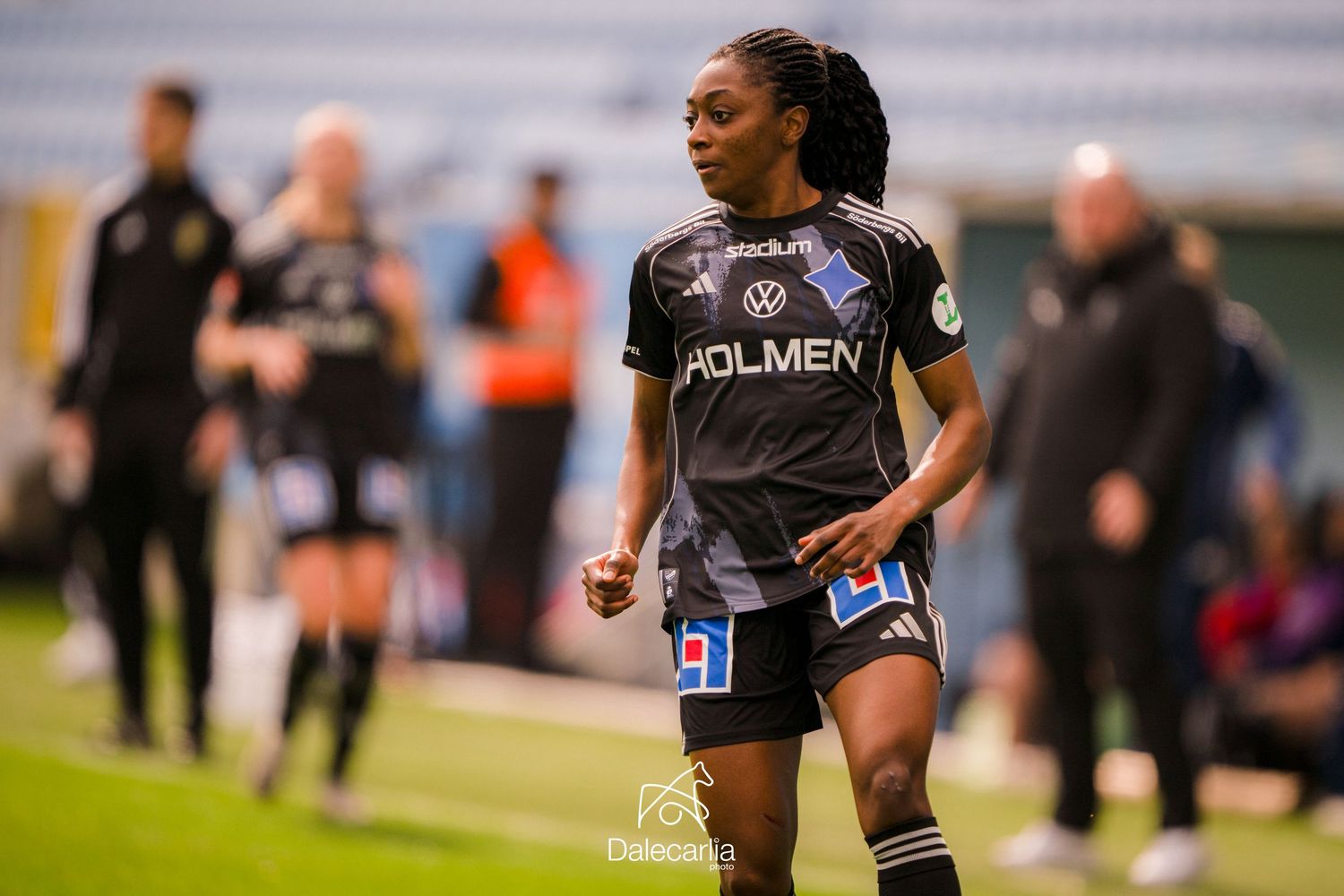 Soccer player in black Colmen jersey number 31 runs on field during competitive match.