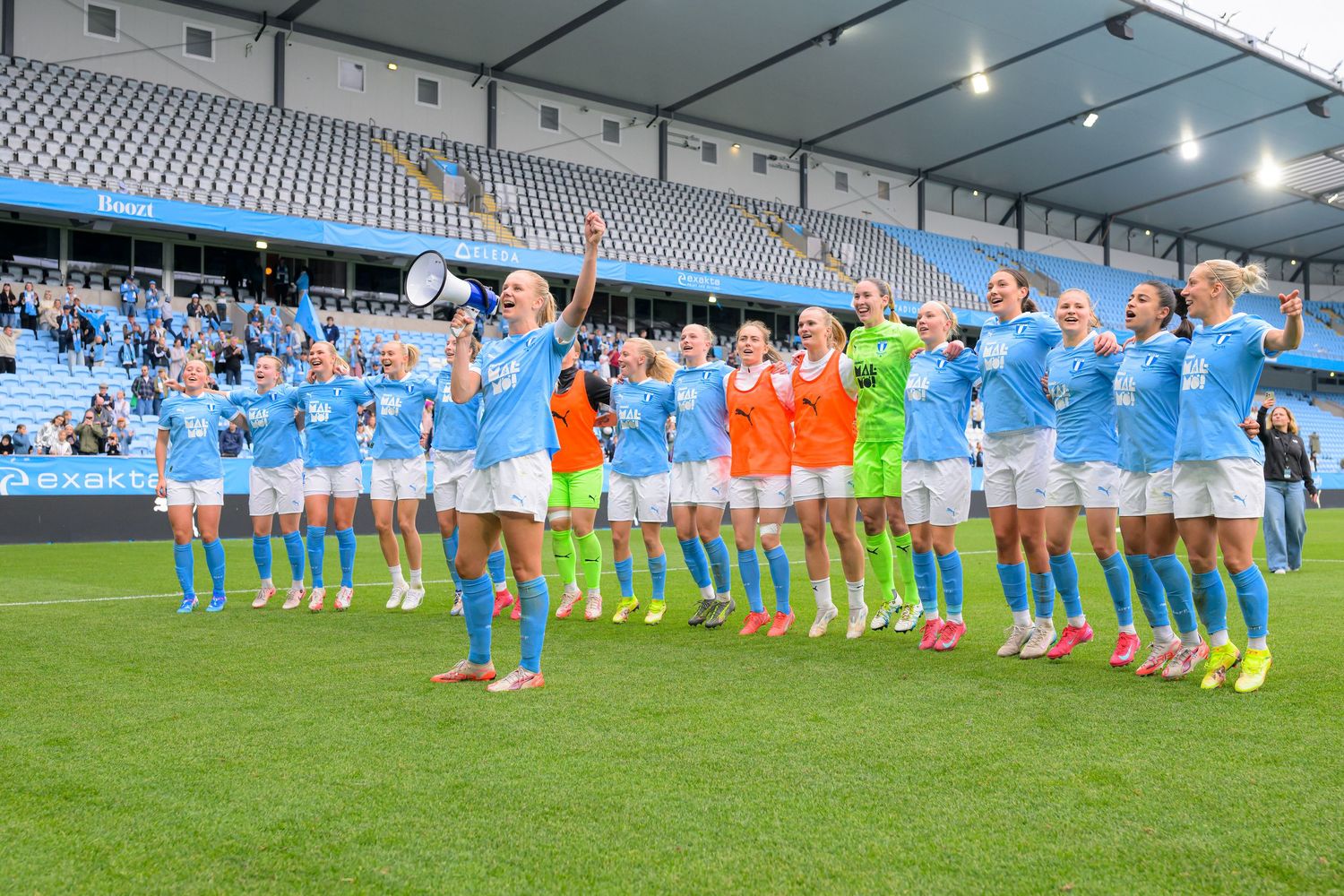 Athletes line up and perform synchronized warm-up exercises on a soccer field before a match.